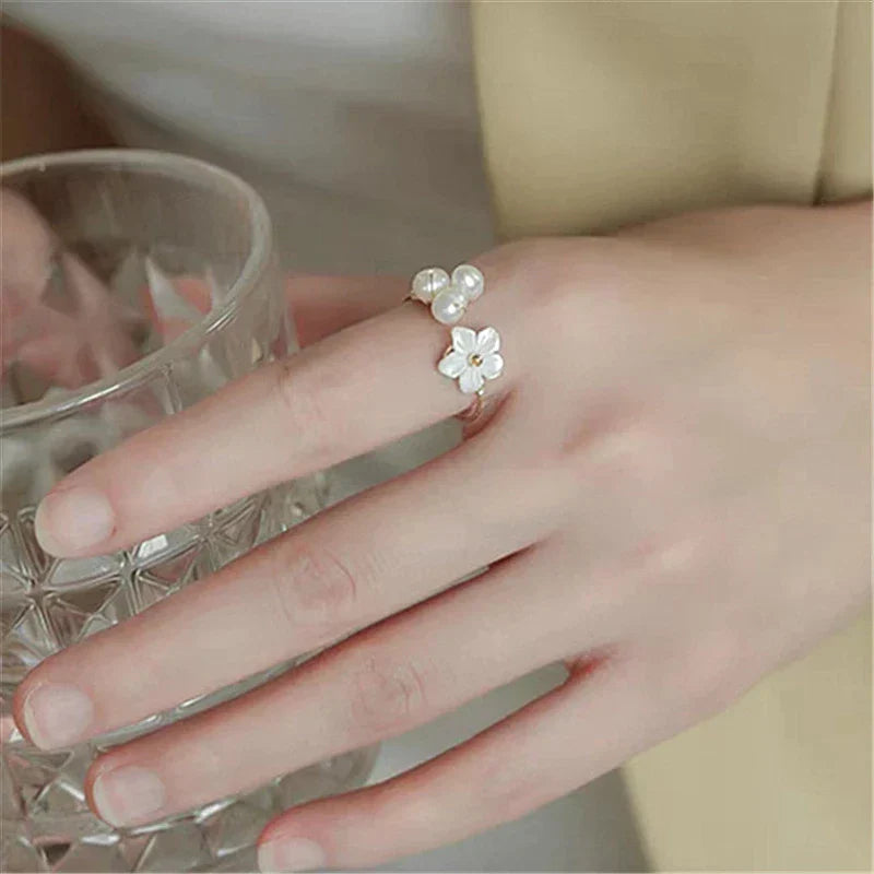 Elegant gold ring with adjustable pearl and flower motifs