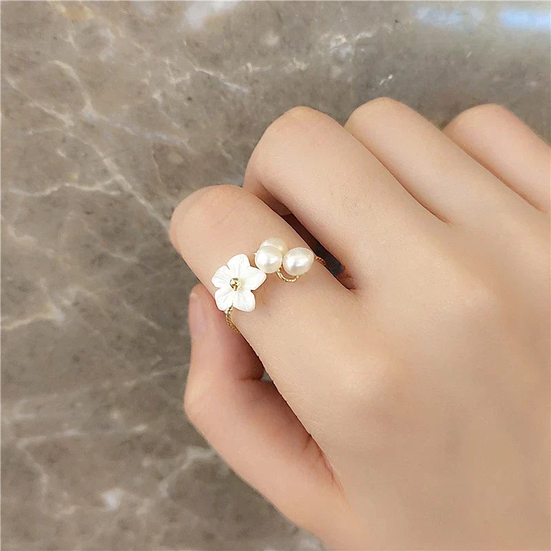 Elegant gold ring with adjustable pearl and flower motifs