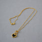 Elegant gold necklace with black and white heart pendants