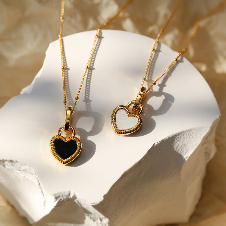 Elegant gold necklace with black and white heart pendants