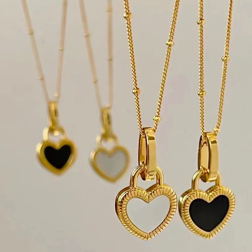 Elegant gold necklace with black and white heart pendants