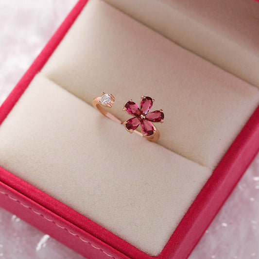 Elegant adjustable ring with a glowing red crystal flower in a noble gold design