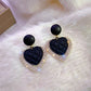 Chic Gold Earrings Adorned with Striking Dark Hearts