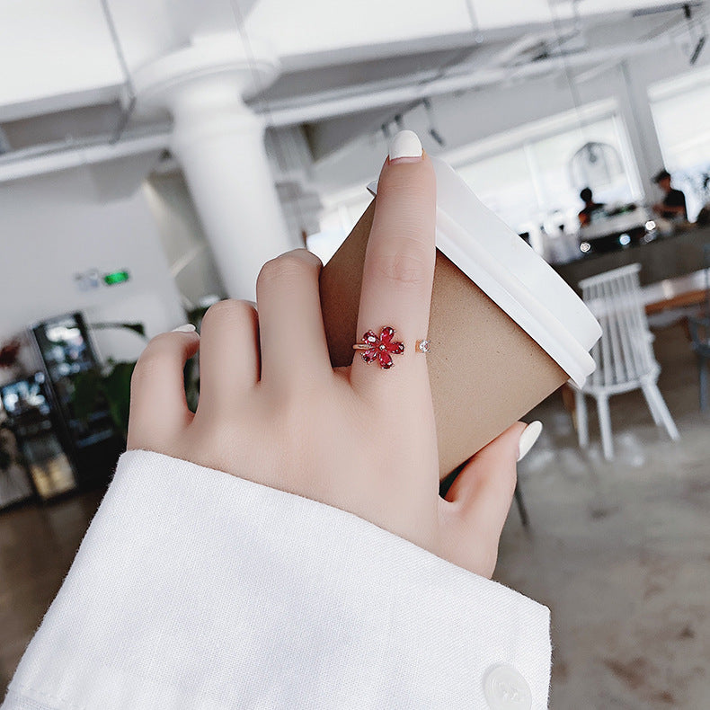 Elegant adjustable ring with a glowing red crystal flower in a noble gold design