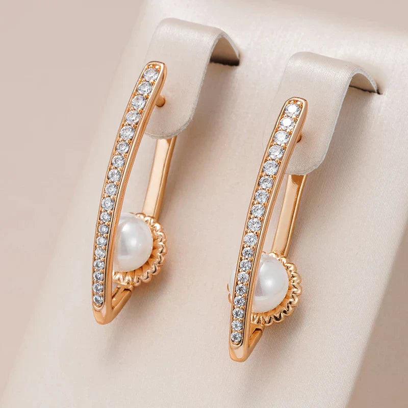 Beautiful gold pointed ear studs with elegant pearls and sparkling zirconia