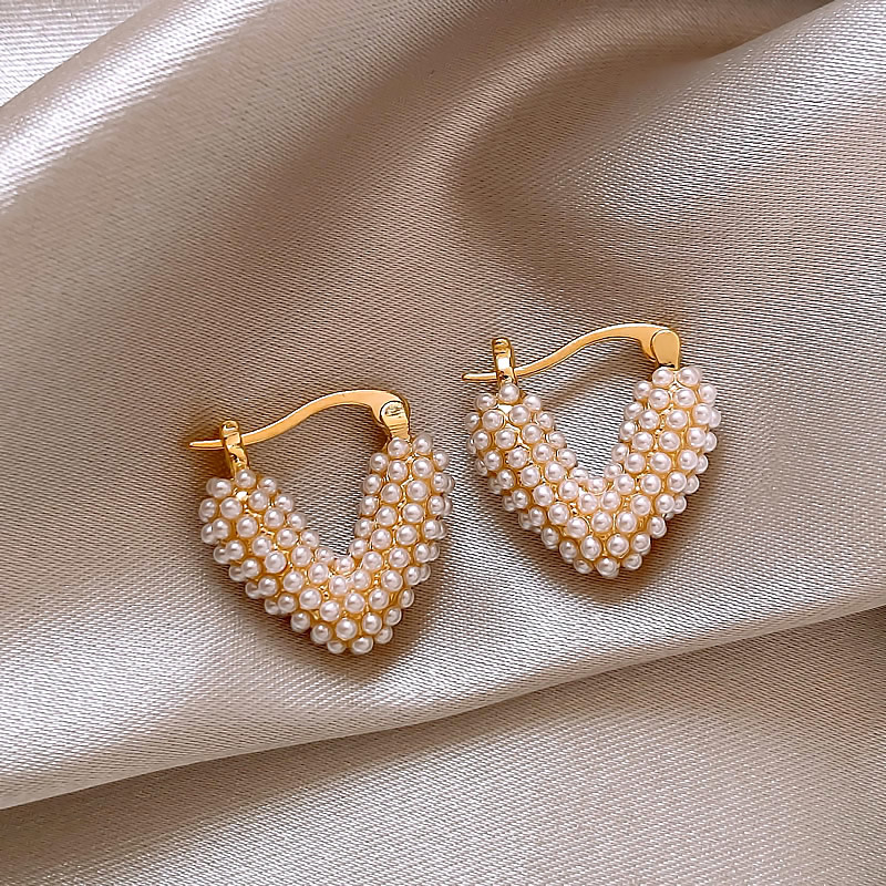 Stunning earrings featuring elegant pearl hearts with gold accents