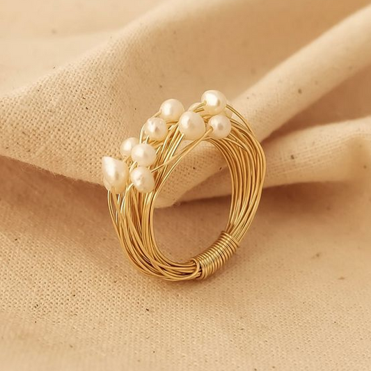 Elegant ring with sparkling pearls and noble golden threads