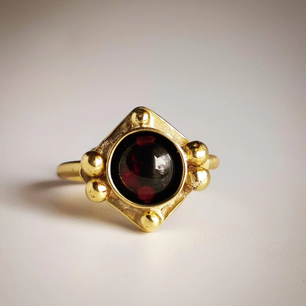 Elegant vintage ring with a radiant red crystal in noble gold